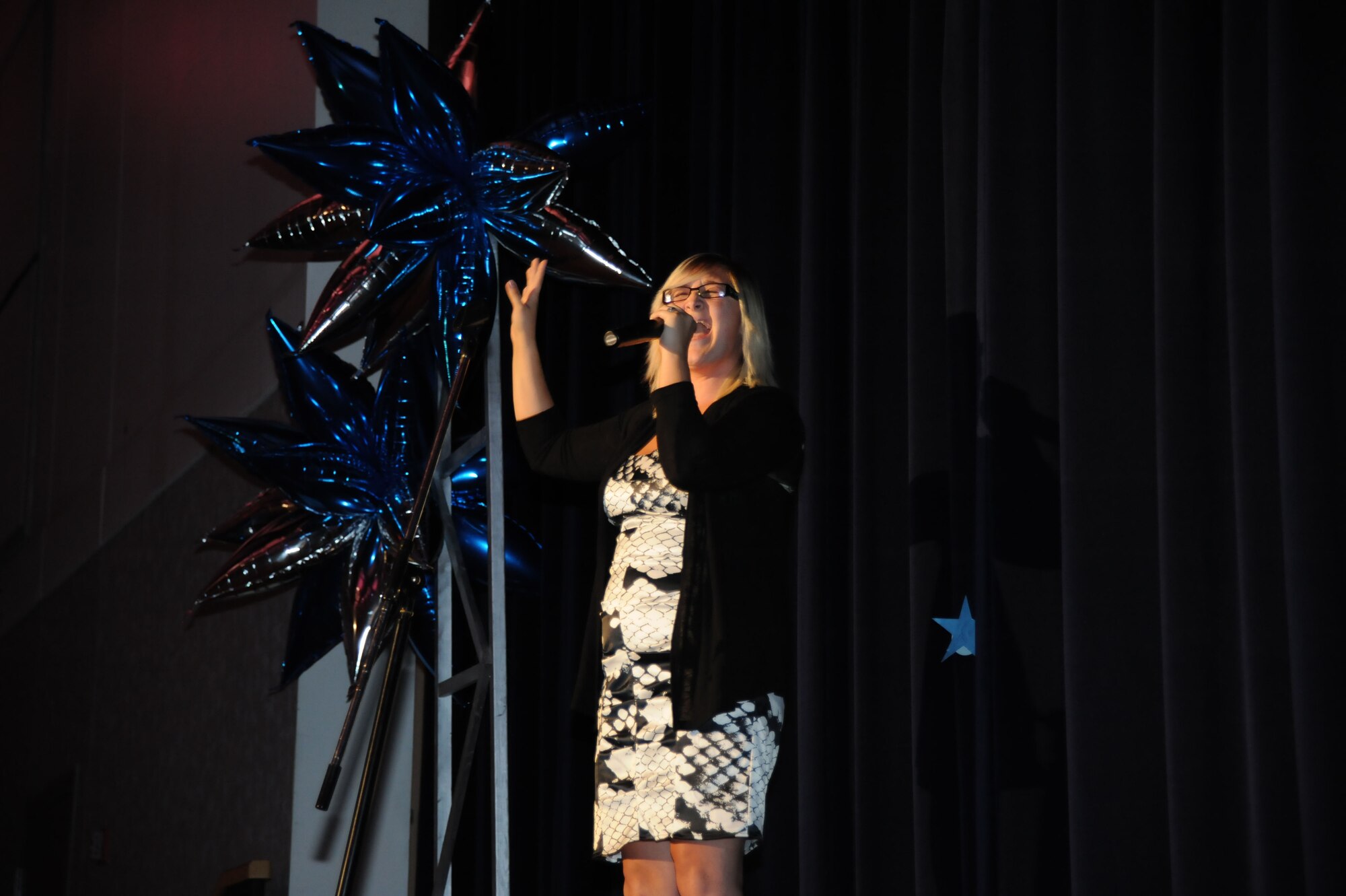 Erica Tillman sings in the Air Mobility Command Icon competition August 11, 2012, McConnell Air Force Base, Kan. The event is held to showcase the talents of the Airmen and family members in AMC, and top performing Airman from each participating base will go on to the finals at Scott Air Force Base, Ill., and compete for a chance to audition for Tops in Blue, the premiere Air Force band. (U.S. Air Force photo/Airman 1st Class Victor J. Caputo)