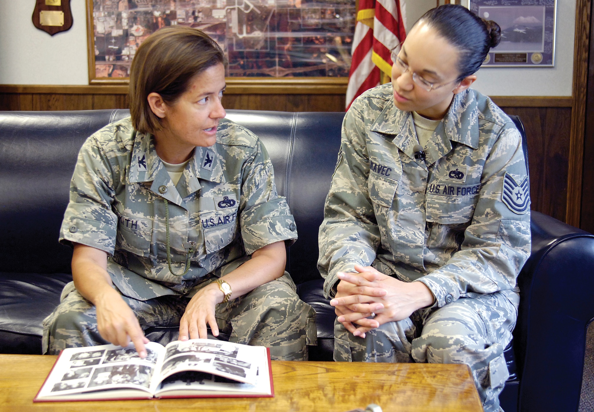 Col. Stella Smith and Tech. Sgt. Malika Likavec graduated from City Honors High School, Buffalo, N.Y. and talk about their respective high school days as they thumb through Colonel Smith’s yearbook recently.  Colonel Smith, squadron commander, and Sergeant Likavec , a maintenance scheduler, have served the Air Force around the world on a journey that brought both to Tinker where a squadron picnic discussion about Sergeant Likavec’s Buffalo Bills sweatshirt revealed their shared hometown beginnings. (Air Force photo by Margo Wright)