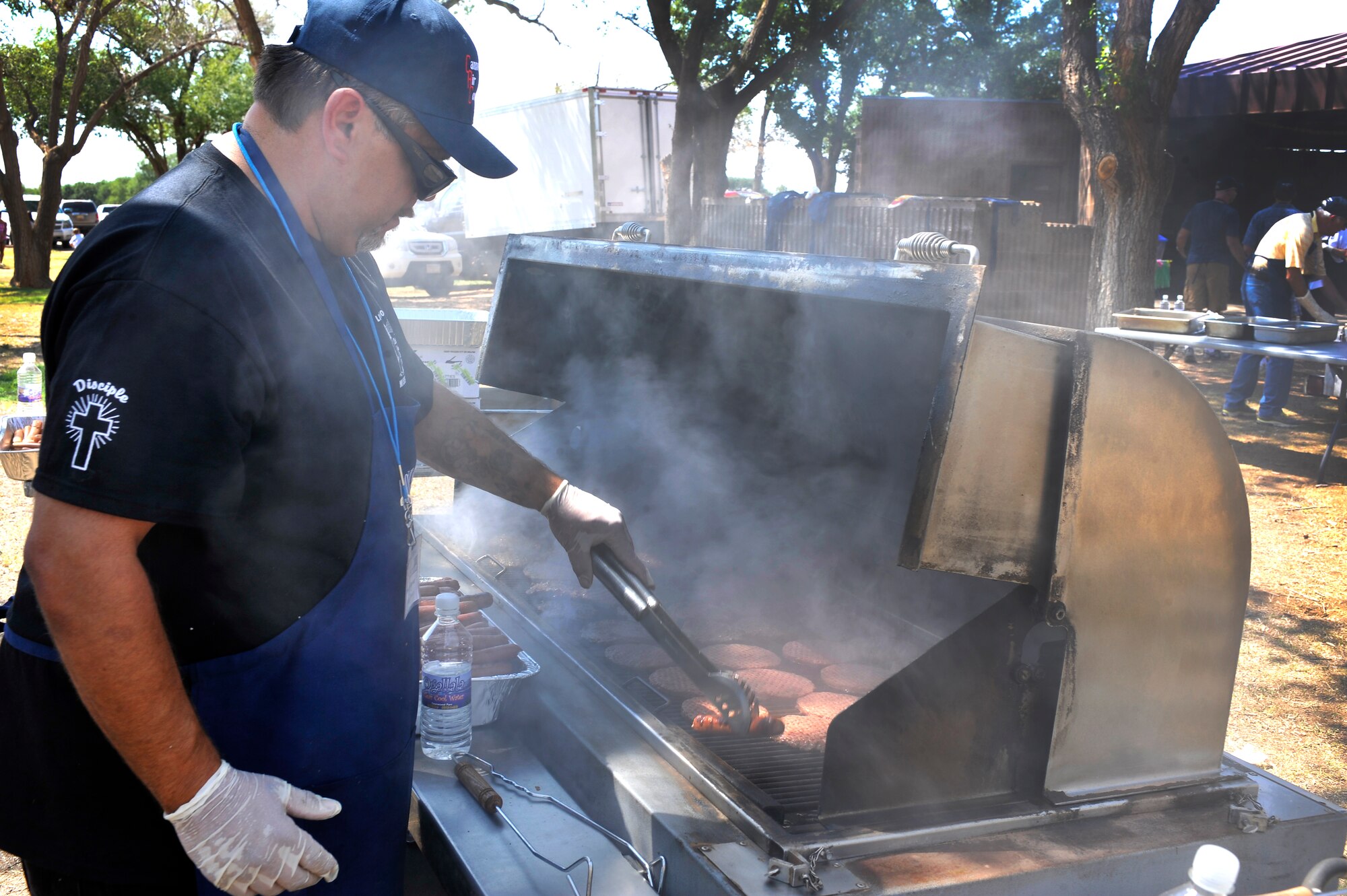 Richard Gomez, The Lighthouse Mission executive director, grills hamburgers during Cannon Appreciation Day at Cannon Air Force Base, N.M., Aug. 10, 2012. The Clovis/Curry County Chamber of Commerce, Committee of Fifty, Military Affairs Committee and the Clovis Industrial Development Corporation came together to sponsor the event for members of the Cannon community. (U.S. Air Force photo/by Airman 1st Class Ericka Engblom)