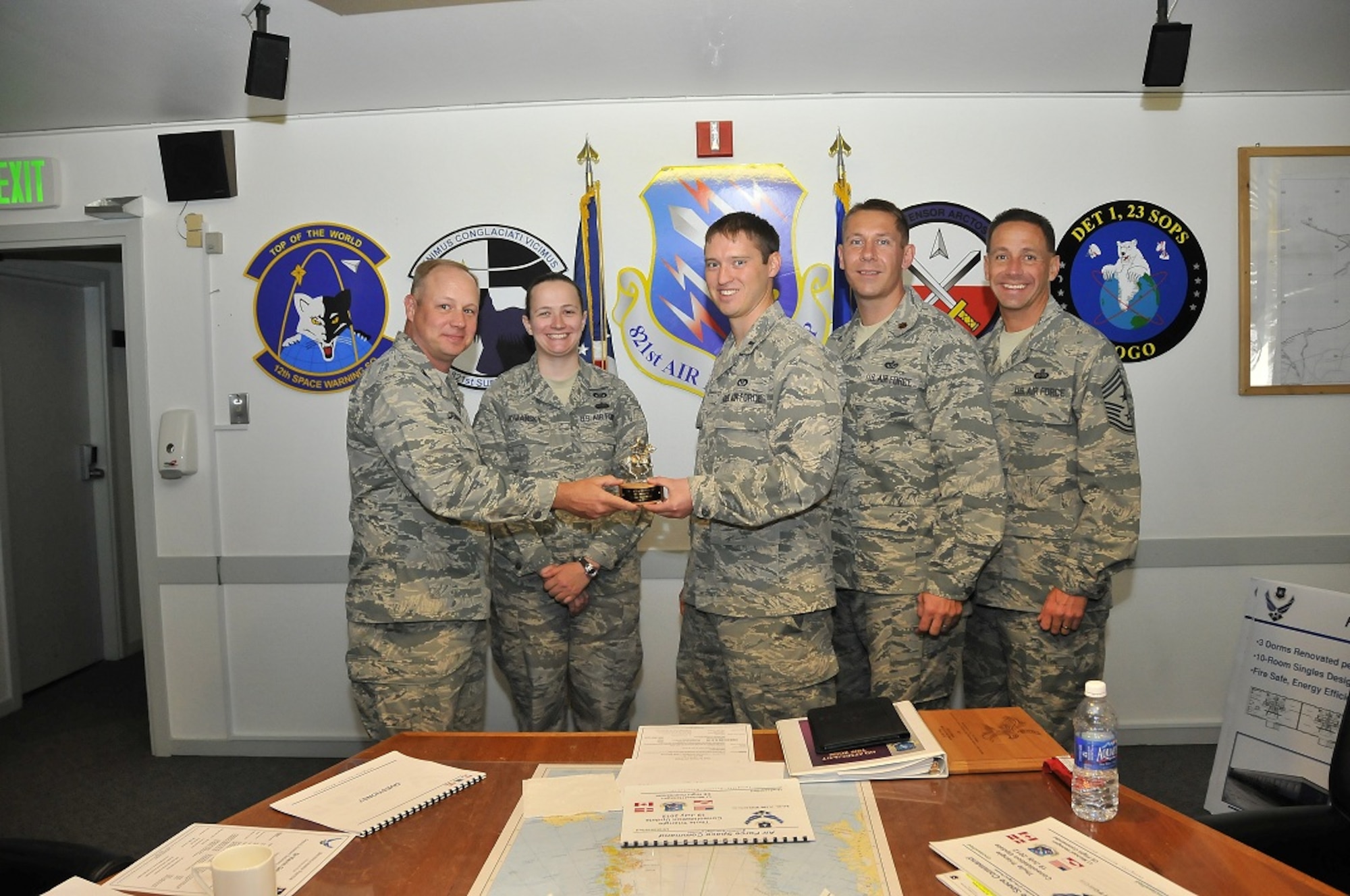 THULE AIR BASE, Greenland – Col. Chris Crawford (left), 21st Space Wing commander; and Chief Master Sgt. Richard Redman (right), 21st SW command chief; present the Gold Knight award to the 821st Support Squadron Civil Engineering Flight for its work in maintaining, improving and supporting Thule Air Base. Accepting the award are (from left to right)Tech. Sgt. Rhonda Howansky, 1st Lt. Michael Hanagan and Maj. Kevin Golart, the 821st Support Squadron commander. Team members not pictured are Capt. Robert Marcucci, Master Sgts. Peter Brestak, Jason Wallace and Tech. Sgt. Adam Giessman.