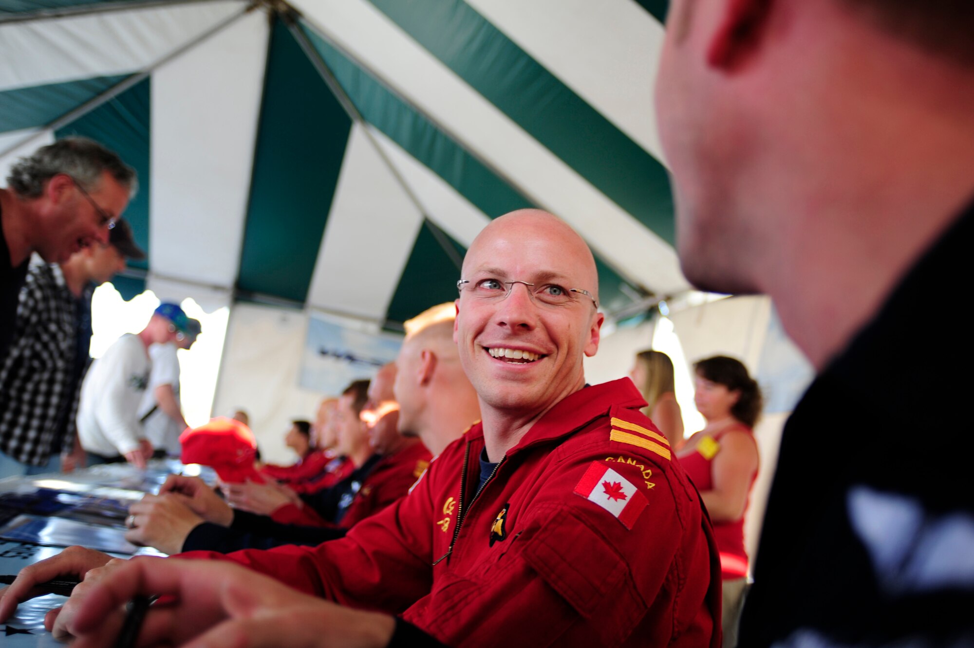 Royal Canadian Air Force Capt. Brent Handy, Snowbird 9 opposing solo pilot jokes with U.S. Air Force Maj. Michael Carletti, Thunderbird 9, flight surgeon, during a joint autograph session at the Abbotsford International Air Show,  Aug.10, 2012. The U.S. Air Force Air Demonstration Squadron "Thunderbirds," performed alongside the Royal Canadian Air Force "Snowbirds" Aug. 10 through 12.  This year's  marked the 50th year of the Abbotsford International Air Show.  (U.S. Air Force photo/Tech Sgt. Manuel J. Martinez)(Released)