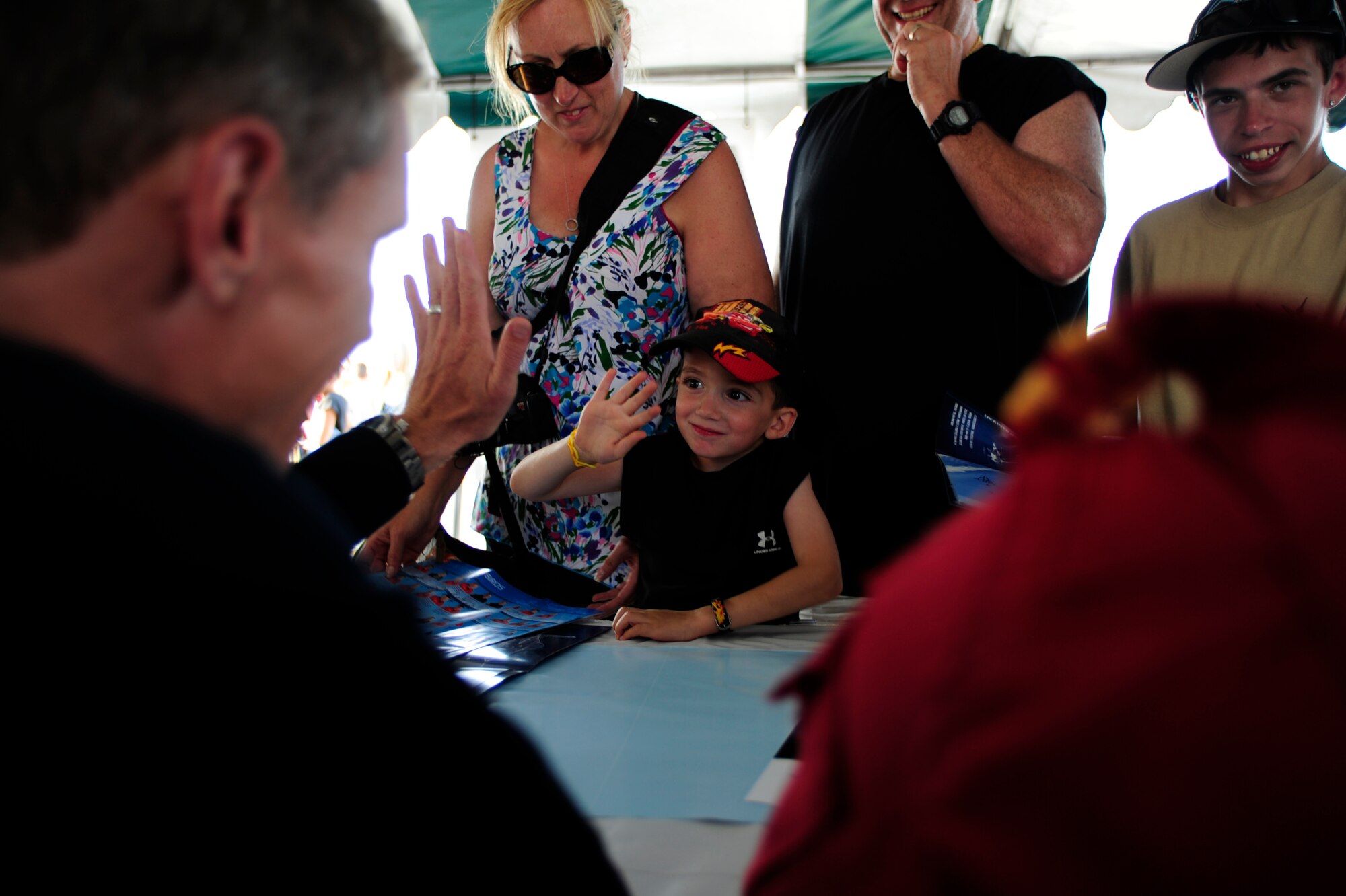 U.S. Air Force Capt. Blaine Jones, Thunderbird 6,  opposing solo pilot gives a child a "high five," during a joint autograph session with the Royal Canadian Air Force "Snowbirds," after their performance at the Abbotsford International Air Show on Aug.10, 2012.  The U.S. Air Force Air Demonstration Squadron "Thunderbirds," performed alongside the Snowbirds Aug. 10 through 12.  This year's  marked the 50th year of the Abbotsford International Air Show.  (U.S. Air Force photo/Tech Sgt. Manuel J. Martinez)(Released)