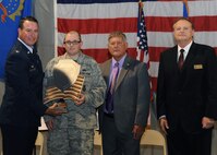 Staff Sgt. Kristoffer Schneider, 319th Medical Support Squadron, is presented with an award of recognition, Aug. 12, 2012, by Col. Tim Bush, 319th Air Base Wing commander, alongside Lynn Stauss, East Grand Forks mayor, and Michael Brown, Grand Forks mayor, during a tribute ceremony to honor military, veterans, policemen and firemen at the East Grand Forks Civic of East Grand Forks. Schneider was recognized for his service during a terrorist attack at Frankfurt International Airport. (U.S. Air Force photo/Senior Airman Amber Bennett)