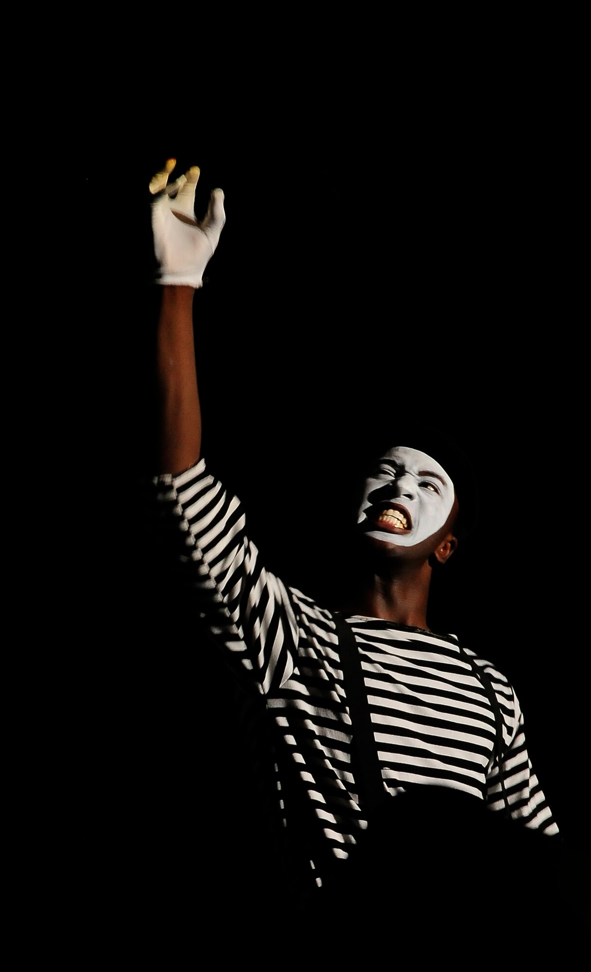 A Tops In Blue member performs a mime routine to Bruno Mar's "Grenade" at the University of Central Missouri in Warrensburg, Mo., Aug. 9, 2012. The show was a majority of song and dance, but the silent skit showed the entertainment team's talent and diversity. Tops In Blue travel throughout the United States and to more than 20 countries during their 10-month tour each year. (U.S. Air Force photo/Senior Airman Cody H. Ramirez)