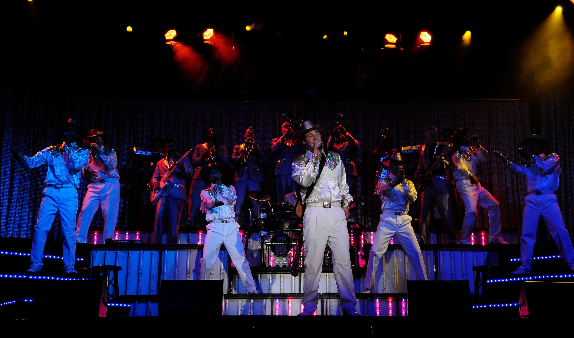 Touching the country genre, Airman 1st Class Timothy Sentz(center), stationed out of Scott Air Force Base, Ill., and other Tops in Blue performers sport western costumes and cowboys hats during their performance at the University of Central Missouri in Warrensburg, Mo., Aug. 9, 2012. Tops In Blue, composed of 35 to 40 talented vocalists, musicians, dancers, and technicians, perform for military personnel and their families throughout the world.  (U.S. Air Force photo/Senior Airman Cody H. Ramirez)