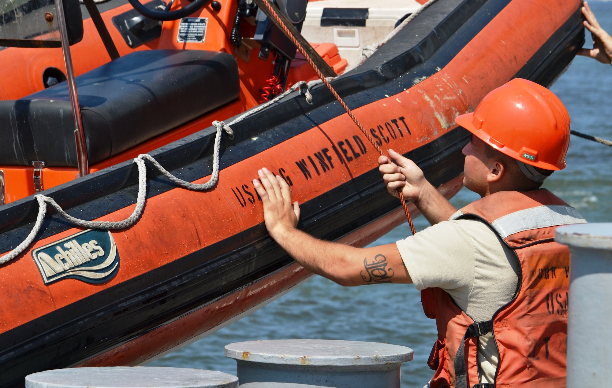 U.S. Army Pfc. Rey Howard, assigned to Small Tug 913, assist in bringing in the LT 805’s work boat after conducting a man-overboard exercise while underway from U.S. Coast Guard Training Center Yorktown, Va., Aug. 3. Dubbed one of the most dangerous jobs in the watercraft field, working on a tug isn’t for the faint of heart. (U.S. Army photo by Sgt. Edwin Rodriguez/Released)