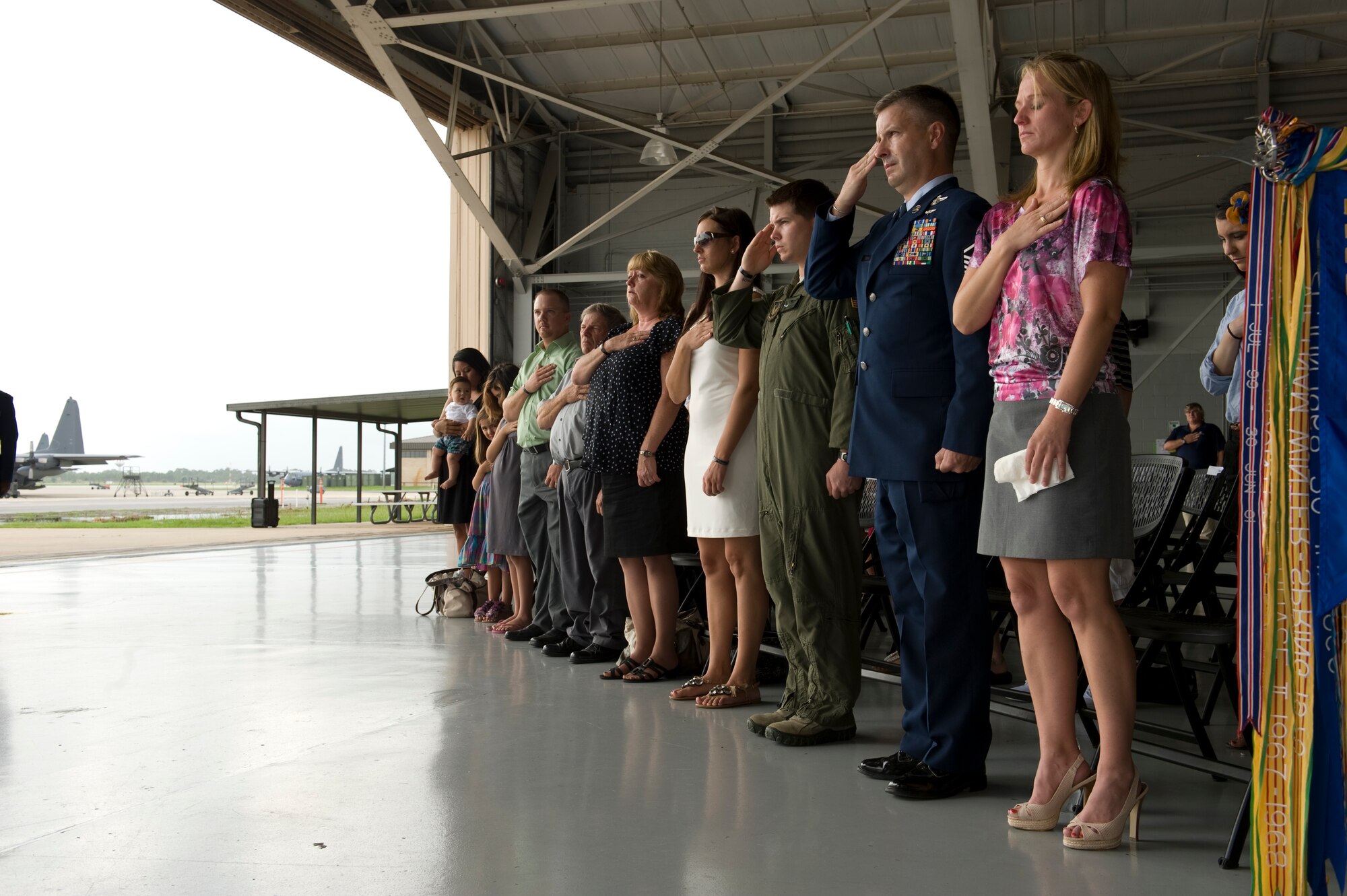 Family members and Airmen stand during the national anthem and pay tribute to the colors at the Commando Hangar on Hurlburt Field Fla., Aug. 10. The Gold Star family members are related to the 13 fallen service members who were being honored at the 10 year anniversary of the Talon 13 and Chariot 55 missions. 
(U.S. Air Force Photo/ Staff Sgt. John Bainter)