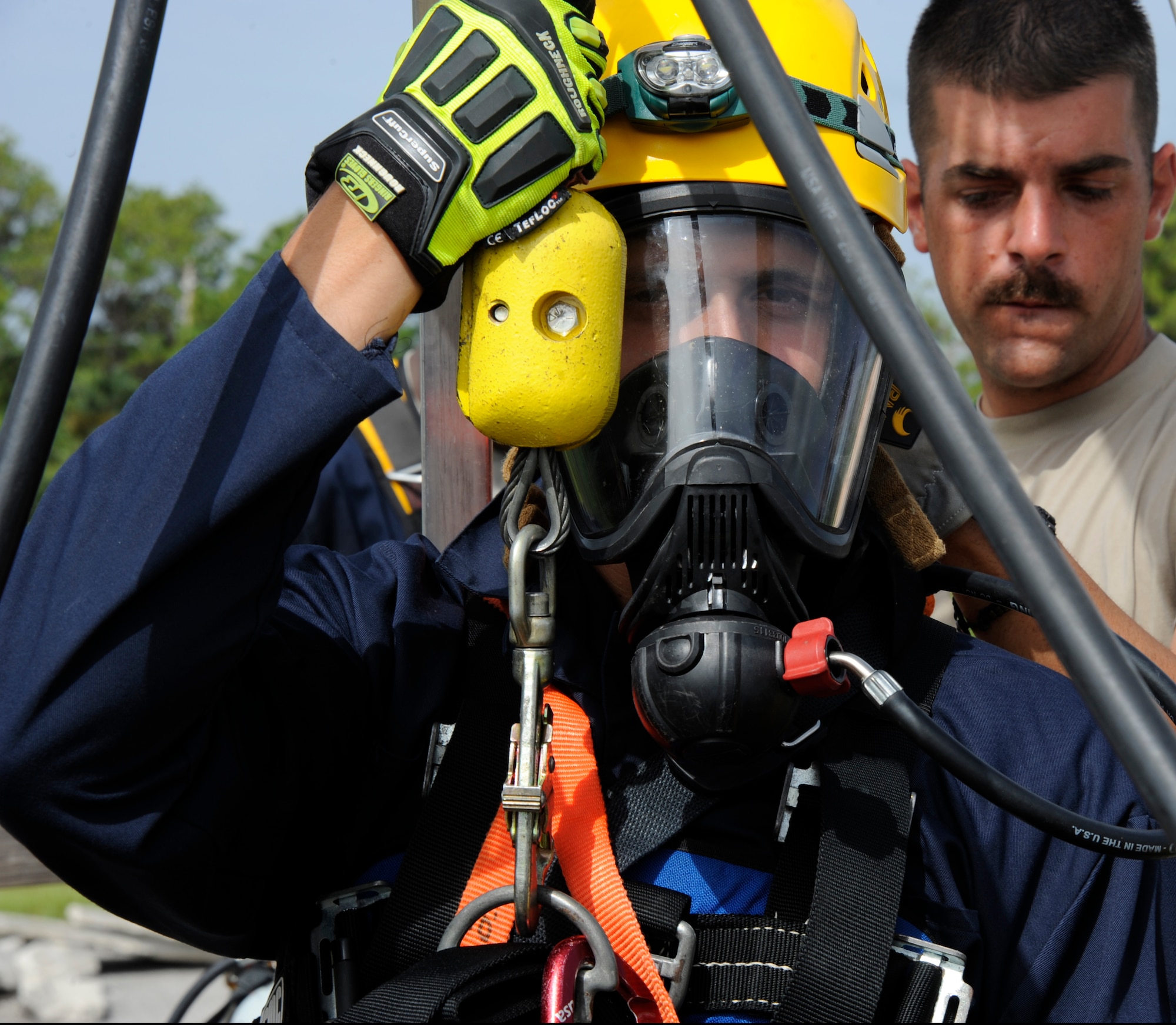 Airman 1st Class Jesse Flagle, 45th Civil Engineer Squadron firefighter from Patrick Air Force Base, Fla., prepares to be lowered into a manhole while Senior Airman Larry McIver, 6th Civil Engineer Squadron firefighter engine operator, assists during confined space rescue training at MacDill AFB, Fla., Aug. 8, 2012. Airmen from Patrick AFB and MacDill AFB participated in a week-long Rescue Technician I course. (U.S. Air Force photo by Airman 1st Class Melanie Bulow-Kelly/released/ cropped to point of interest)