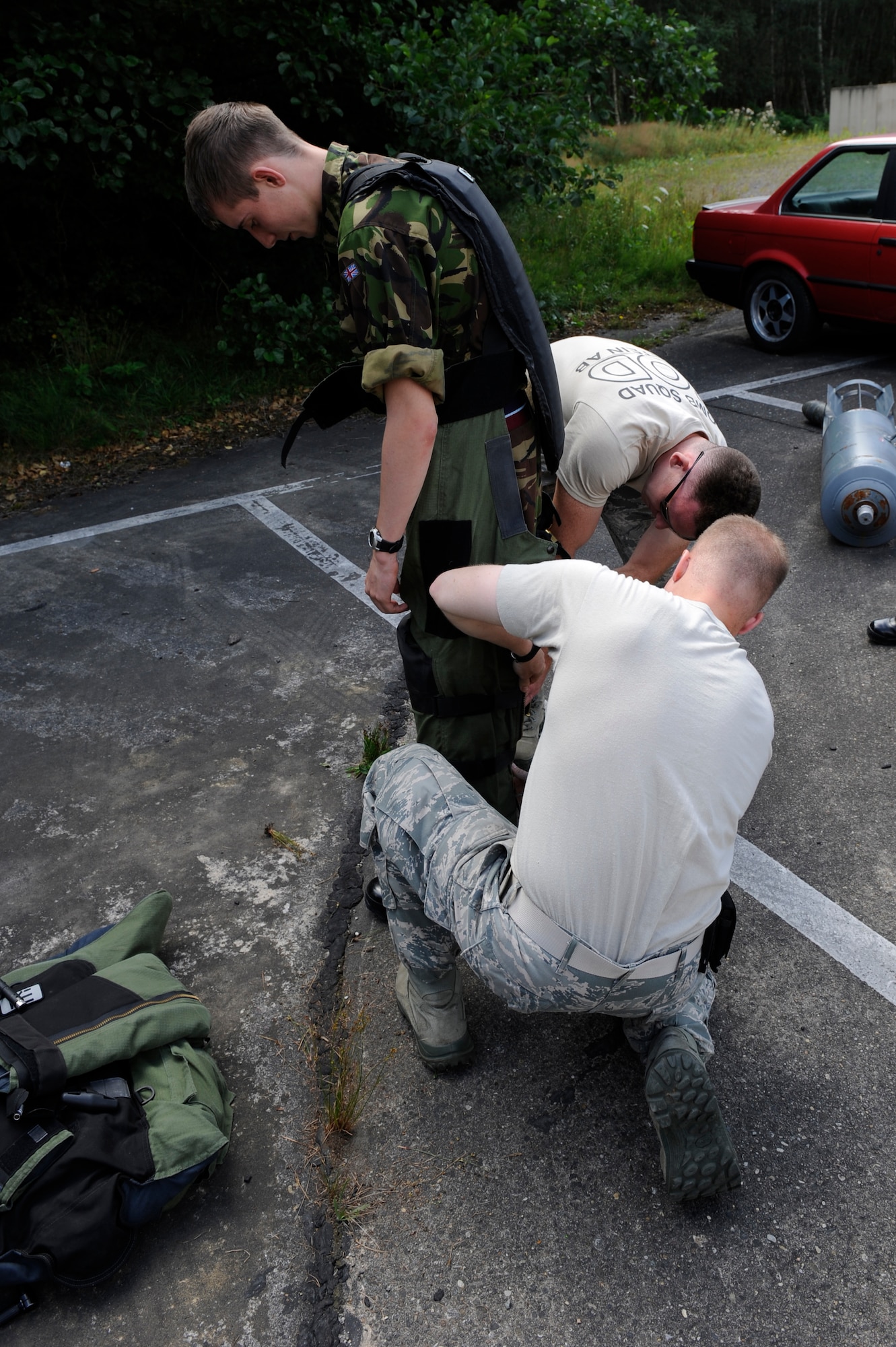 Airmen of the 886th Civil Engineer Squadron, explosive ordnance disposal flight, assists  Matthew Leathard, British Royal Air Force cadet, don a bomb disposal suit during his tour on Ramstein Air Base, Germany, Aug. 8, 2012. The Explosive Ordnance Disposal flight gave briefings to Royal Air Force cadets on different types of explosives and the procedures used to protect themselves from improvised explosive devices when deployed. (U.S. Air Force photo/ Senior Airman Aaron-Forrest Wainwright)