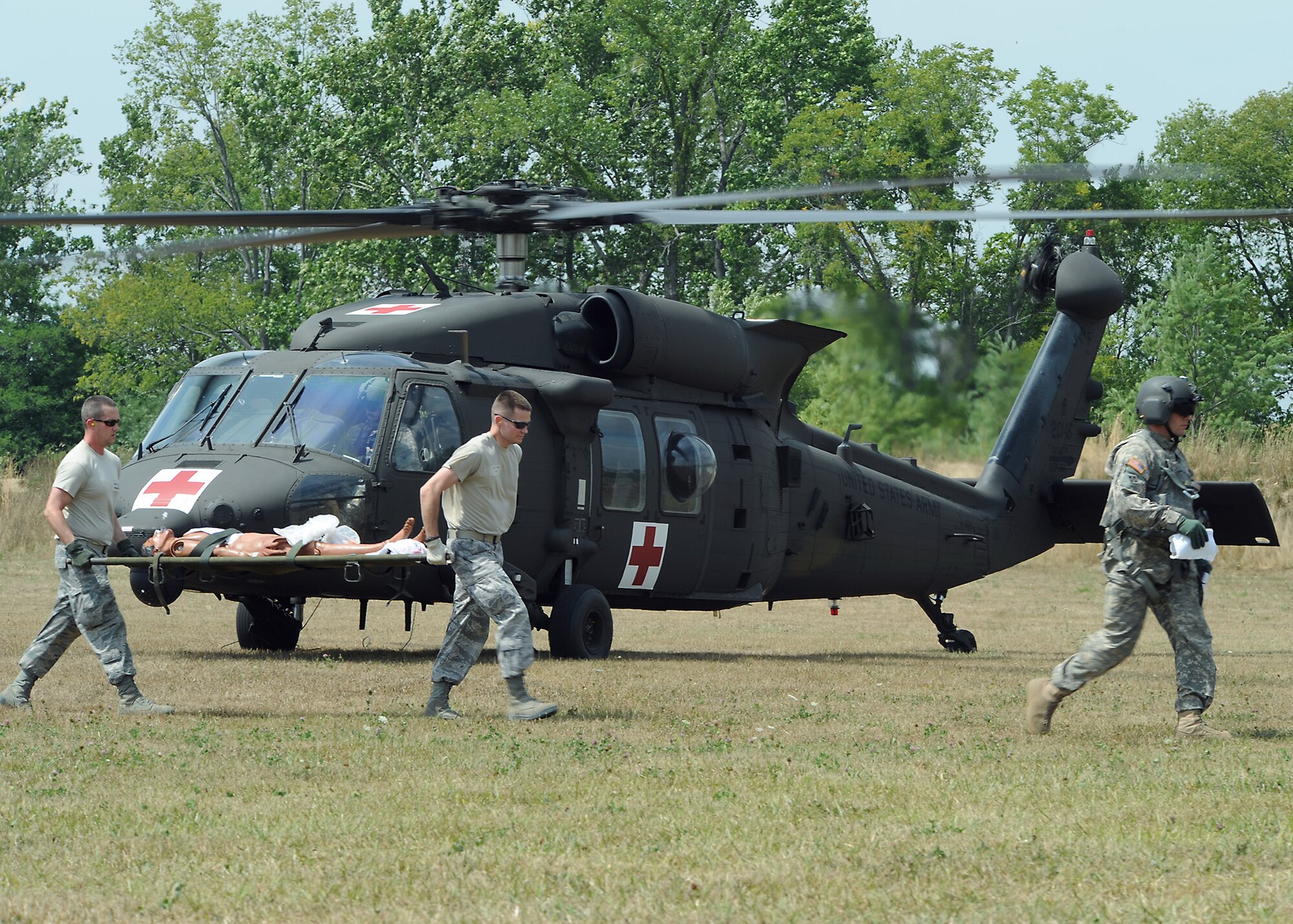 U.S. Air Force medical members assigned to the Expeditionary Medical Support carry a simulated injured patient from a U.S. Army HH-60M Blackhawk helicopter during a medical evacuation for Exercise Vibrant Response at Contingency Operating Location Nighthawk on Camp Atterbury, Ind., July 30, 2012. (Official DOD photo by U.S. Air Force Tech. Sgt. Tony Tolley/Released)