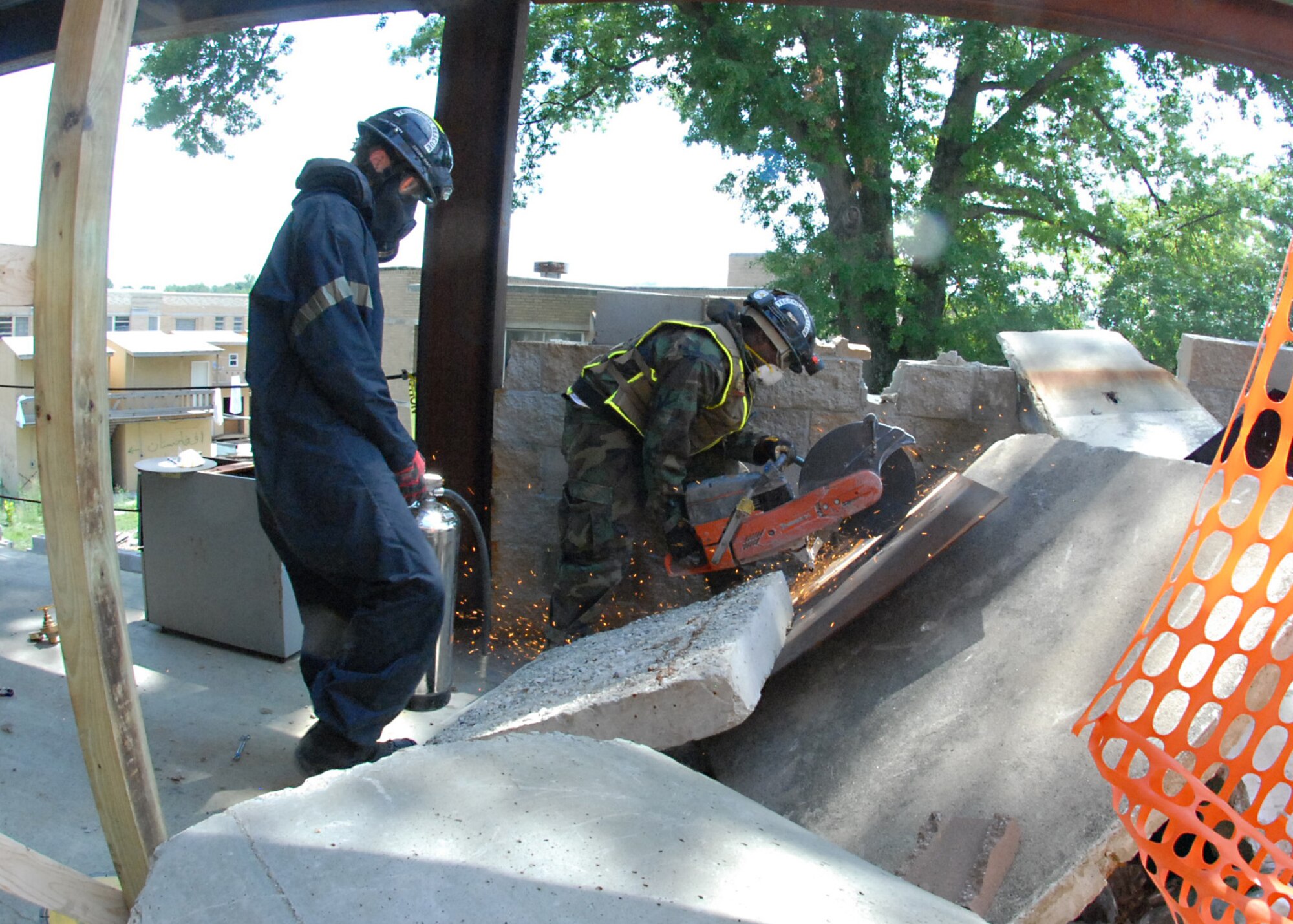 Marines from the Chemical, Biological Incident Response Force use a cordless rotary saw to cut through a sheet of metal during a search and extraction operation, which is part of the Vibrant Response 13 field training exercise at the Muscatatuck Urban Training Center, Ind., July 29. The CBRIF unit used high-powered tools and equipment to maneuver through four levels of a collapsing building and evacuate civilians during the training venue.  (Official DOD photo by U.S. Army Sgt. Terence Ewing/Released)