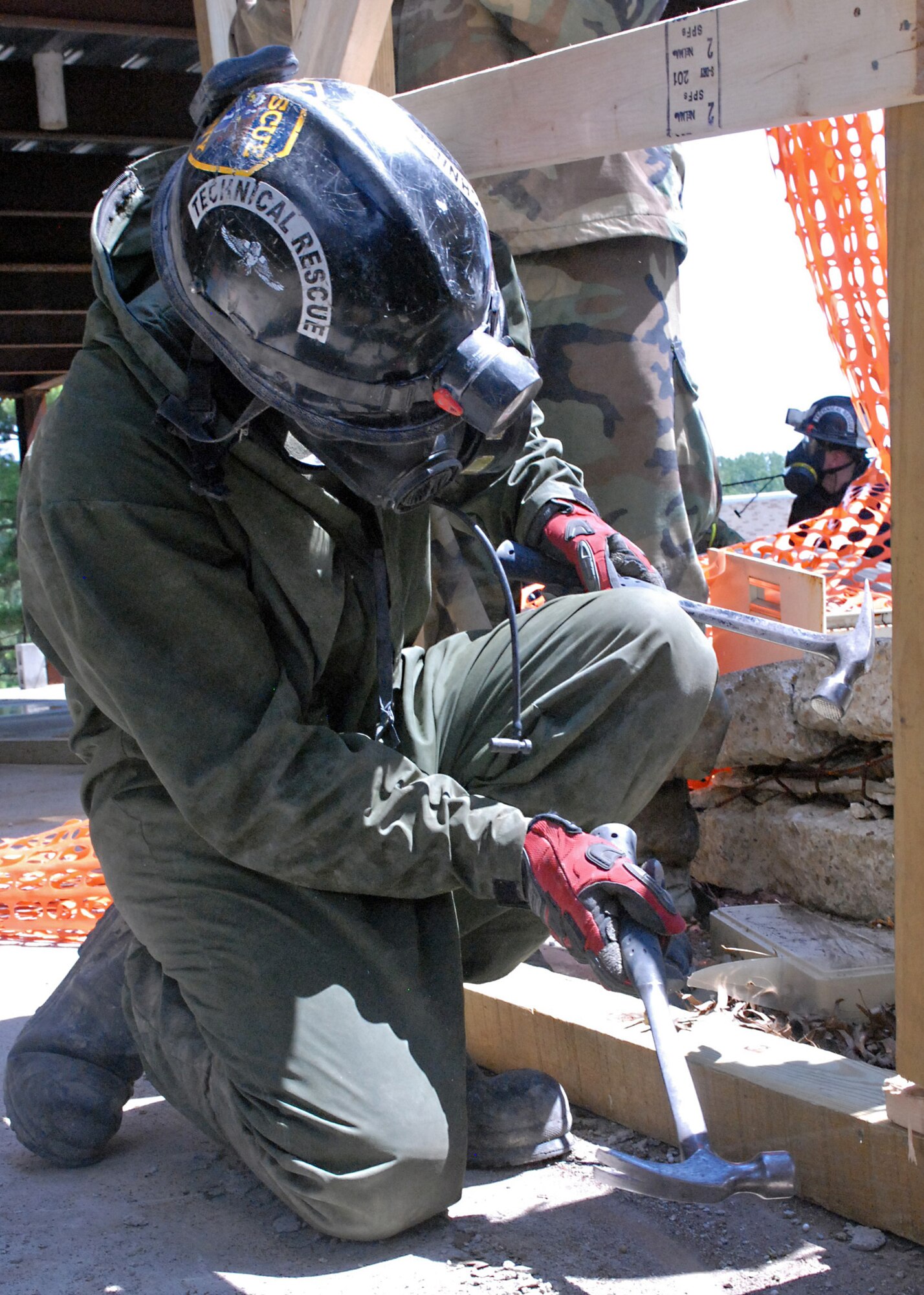 A Marine assigned to the Chemical, Biological Incident Response Force hammers wooden bracing together to support a collapsing building during a Vibrant Response 13 field training exercise at the Muscatatuck Urban Training Center, Ind., July 29. The CBIRF unit was responsible for decontaminating, treating and evacuating displaced civilians in the collapsed building during the simulated training exercise.   (Official DOD photo by U.S. Army Sgt. Terence Ewing/Released)