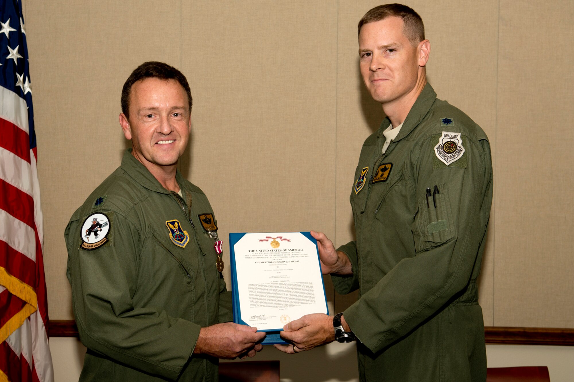 U.S. Air Force Lt. Col. Todd Callahan is presented the Air Force Meritorious Service Medal by Lt. Col. William Wharton, 11th Bomb Squadron commander, during a retirement ceremony on Aug. 9, 2012, Barksdale Air Force Base, La. Callahan (left), a B-52 Electronic Warfare Officer, is retiring after serving 27 years in the military and has flying hours in the EA-6 Prowler, C-130 Hercules and the B-52G and H aircraft. (U.S. Air Force photo by Master Sgt. Greg Steele/Released)
