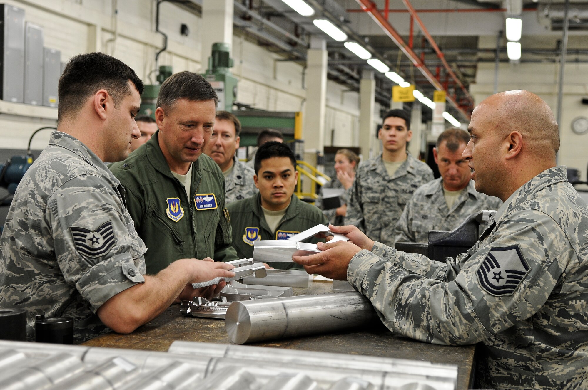 ROYAL AIR FORCE LAKENHEATH, England -- Master Sgt. Duane Nastav (right), 48th Equipment Maintenance Squadron assistant fabrication flight chief, and Tech. Sgt. Jeremy Hulett (left), 48th EMS metal technologies section chief, show Brig. Gen. Jon Norman, Director, United States Air Forces in Europe-United Kingdom, UHF antenna bulk-head parts from an F-15 aircraft that is being repaired, during his visit of the 48th Fighter Wing Aug. 9, 2012. Norman toured the 48th Maintenance Group, 48th Medical Group and various locations around RAF Lakenheath.  (U.S. Air Force photo by Senior Airman Connor Estes)