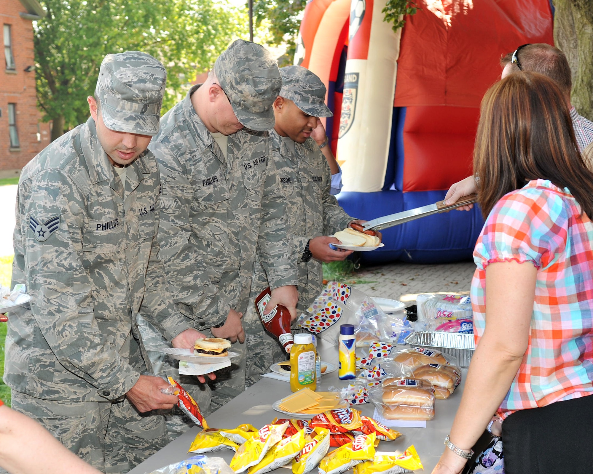 RAF MILDENHALL, England – Airman stationed on RAF Mildenhall make their way through the food line at the college fair and barbecue Aug. 10, 2012, in Washington Square. In addition to information tables, the fair featured a barbecue and family activities available to all Airmen on base and their families. (U.S. Air Force photo/Senior Airman Jerilyn Quintanilla) 