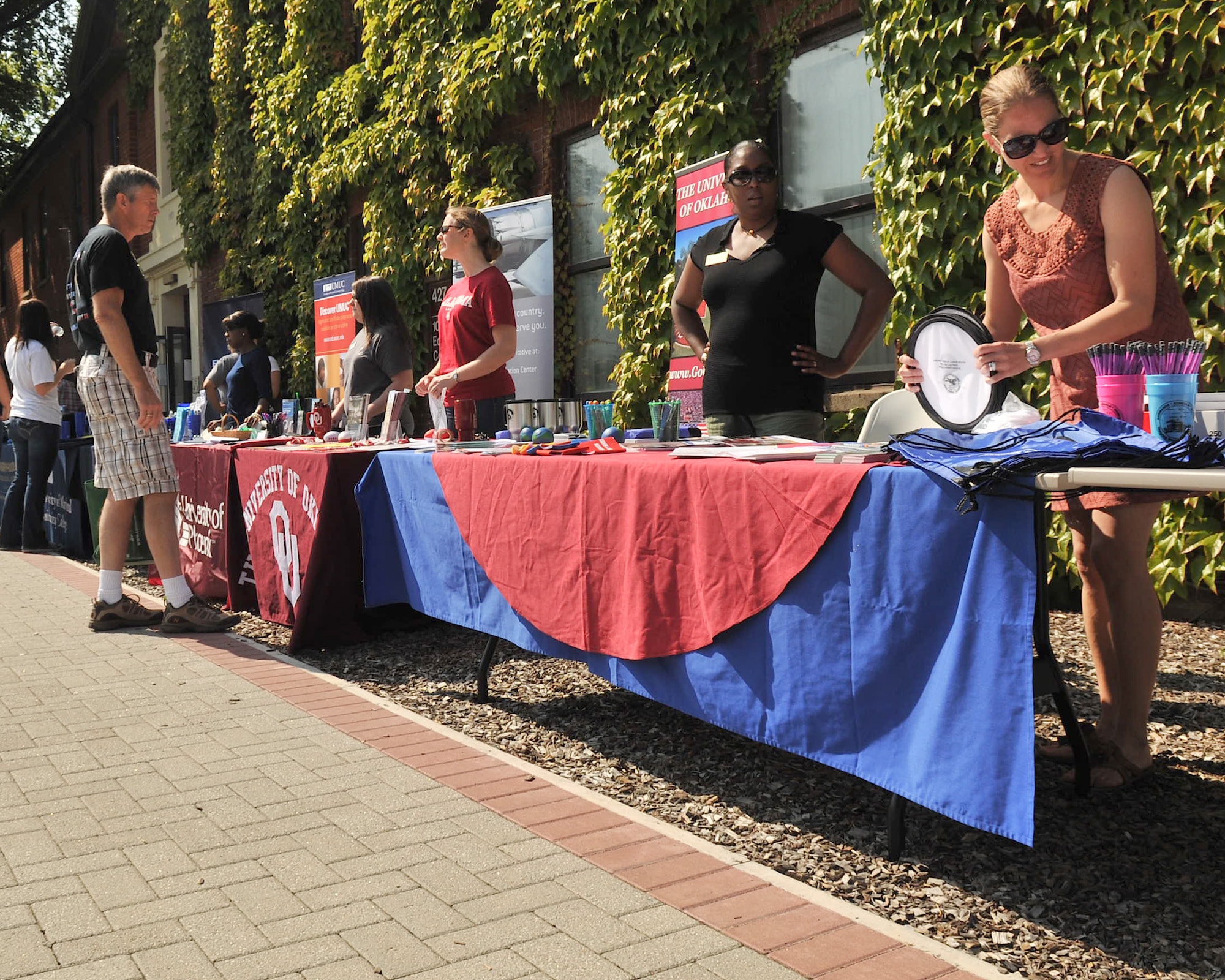 RAF MILDENHALL, England – College field representatives, members from the Airman and Family Readiness Center and a school liaison prepare their information tables at the college fair and barbecue Aug. 10, 2012, in Washington Square. In addition to information tables, the fair featured a barbecue and family activities available to all Airmen on base and their families. (U.S. Air Force photo/Senior Airman Jerilyn Quintanilla) 