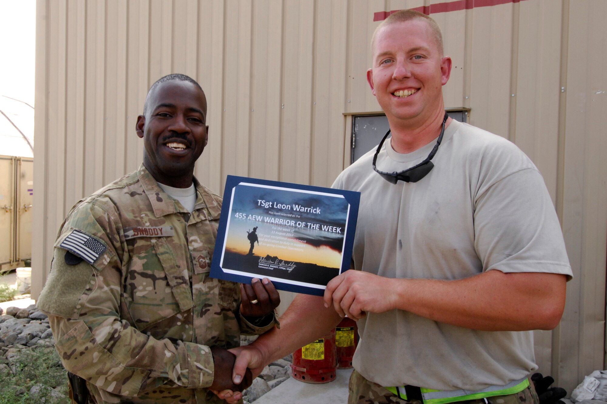 CMSgt Marcus Snoddy, 455th Air Expeditionary Wing command chief, presents the Warrior of the Week certificate to TSgt Leon Warrick, 455th Expeditionary Aircraft Maintenance Squadron aircraft crew chief, at Bagram Airfield, Afghanistan, Aug. 13, 2012. As an A-10C Thunderbolt II crew chief, Warrick’s primary duties include accomplishing all scheduled and non-scheduled inspections, the launch and recovery of aircraft, aircraft forms documentation, and the generation of a safe, quality, reliable weapons platform to accomplish the mission. While deployed to BAF, he has had 12 Personnel Evaluations and one Quality Verification Inspection assessment by Quality Assurance and has earned a 100% pass rate. (U.S. Air Force photo/SSgt Jeff Nevison)