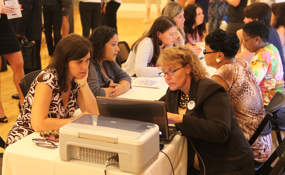 A military spouse receives coaching for her resume at the Marston Pavilion aboard Marine Corps Base Camp Lejeune during the Military Spouse Business Alliance Hiring Fair and Career Forum Aug. 9. There were many presentations held along with resume and interview coaching. 