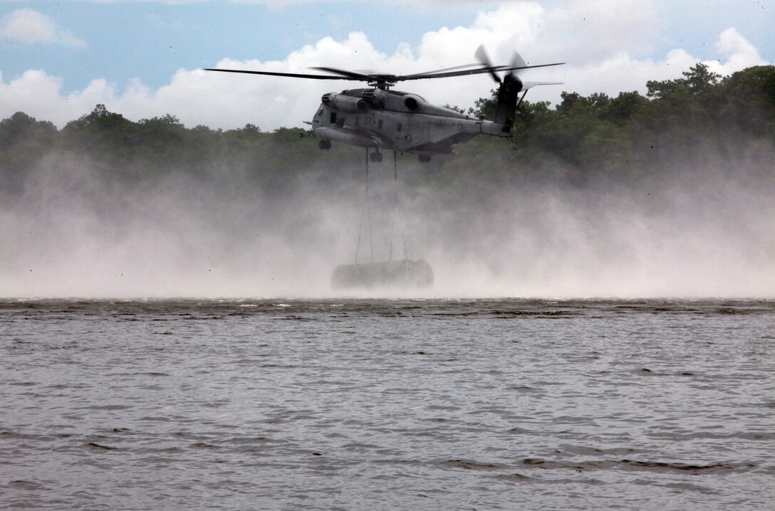 A CH-53E Super Stallion with Marine Heavy Helicopter Squadron 366, 2nd Marine Aircraft Wing drops a section of an improved ribbon bridge during a training exercise with 8th Enginner Support Battalion, 2nd Marine Logistics Group aboard Camp Lejeune, N.C., Aug. 8, 2012. The training made history. It marked the first time in 10 years that Bridge Company, 8th ESB collaborated with elements of 2nd MAW to open and construct a collapsable raft while already in water. (Photo by Pvt. Franklin E. Mercado)