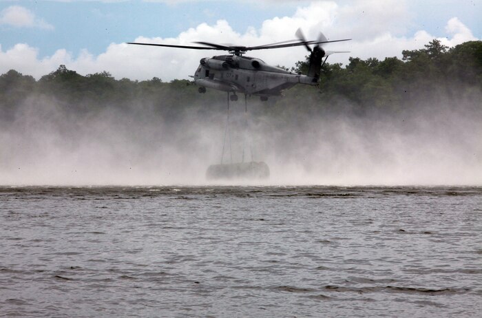 A CH-53E Super Stallion with Marine Heavy Helicopter Squadron 366, 2nd Marine Aircraft Wing drops a section of an improved ribbon bridge during a training exercise with 8th Enginner Support Battalion, 2nd Marine Logistics Group aboard Camp Lejeune, N.C., Aug. 8, 2012. The training made history. It marked the first time in 10 years that Bridge Company, 8th ESB collaborated with elements of 2nd MAW to open and construct a collapsable raft while already in water. (Photo by Pvt. Franklin E. Mercado)