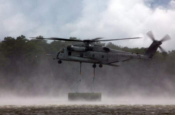 A CH-53E Super Stallion with Marine Heavy Helicopter Squadron 366, 2nd Marine Aircraft Wing drops a section of a raft during a training exercise with 8th Enginner Support Battalion, 2nd Marine Logistics Group aboard Camp Lejeune, N.C., Aug. 8, 2012. The training made history. It marked the first time in 10 years that Bridge Company, 8th ESB collaborated with elements of the 2nd MAW to open and construct a collapsable raft while already in water. (Photo by Pvt. Franklin E. Mercado)
