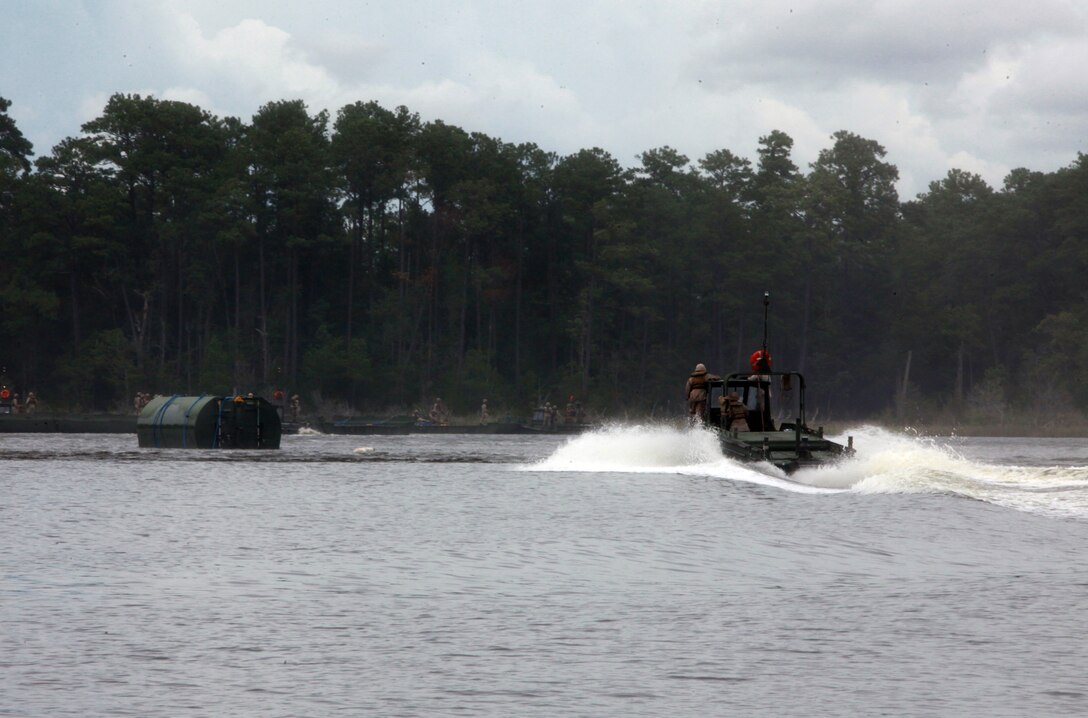 A water craft races out to retrieve a section of an improved ribbon bridge during an 8th Engineer Support Battalion, 2nd Marine Logistics Group training exercise aboard Camp Lejeune, N.C., Aug. 8, 2012. The exercise simulated a humanitarian relief effort in which trucks could not reach the area that a bridge was needed, therefore, the sections had to be individually airlifted and assembled on-site. (U.S. Marine Corps photo by Pvt. Franklin E. Mercado)
