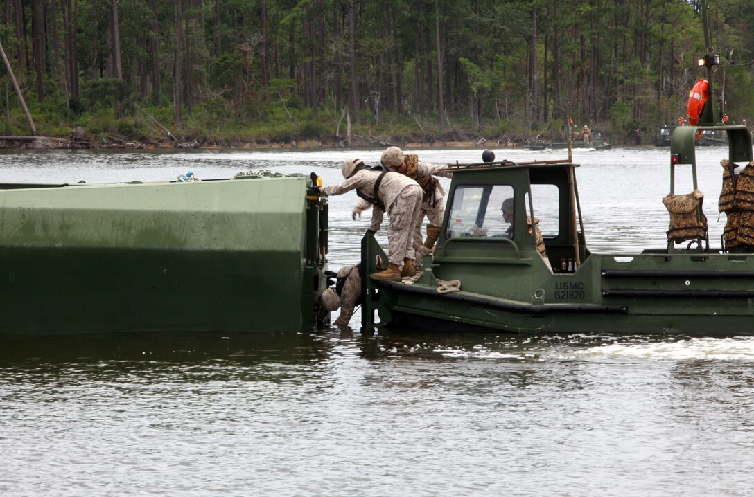 Marines with 8th Engineer Support Battalion, 2nd Marine Logistics Group work to open a section of an improved ribbon bridge during a training exercise aboard Camp Lejeune, N.C., Aug. 8, 2012. During the exercise, a helicopter lowered parts of the bridge into the water as troops waited near the shore. The Marines raced to the individual sections floating in the bay to open and secure them after the raft was in the water. (U.S. Marine Corps photo by Pvt. Franklin E. Mercado)