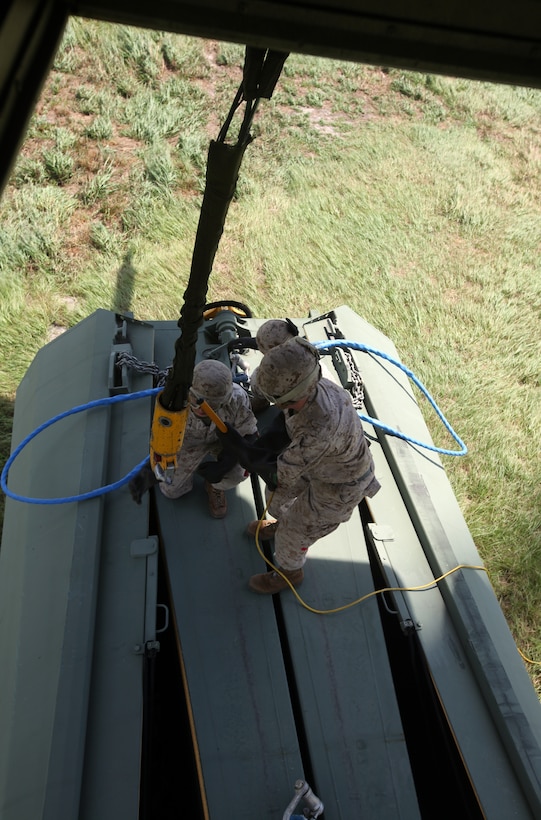 Marines with 2nd Marine Logistics Group attach a section of an improved ribbon bridge to a CH-53E Super Stallion during a training exercise aboard Camp Lejeune, N.C., Aug. 9, 2012. Landing support specialists supported the exercise by hooking sections of the improved ribbon bridge to the helicopters, which dropped the sections in a bay minutes later. (U.S. Marine Corps photo by Pvt. Franklin E. Mercado)