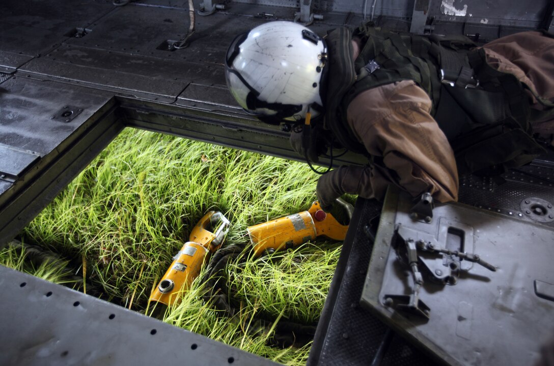 A Marine with 2nd Marine Aircraft Wing prepares the hooks to attach sections of an improved ribbon bridge during an 8th Engineer Support Battalion, 2nd Marine Logistics Group training exercise aboard Camp Lejeune, N.C., Aug. 9, 2012. During the exercise, the helicopter lowered parts of the bridge into the water as Marines with 8th ESB, waited near the shore. The Marines raced to the individual sections floating in the bay to open and secure them after the raft was in the water.  (U.S. Marine Corps photo by Pvt. Franklin E. Mercado)