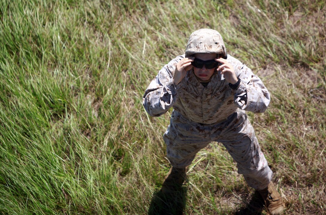 Lance Cpl. Barry Anderson, a landing support specialist with Combat Logistics Regiment 27, 2nd Marine Logistics Group, signals a CH-53E Super Stallion during a training exercise aboard Camp Lejeune, N.C., Aug. 9, 2012. Landing support specialists supported the exercise by hooking sections of an improved ribbon bridge to the helicopters, which dropped the sections in a bay minutes later.  (U.S. Marine Corps photo by Pvt. Franklin E. Mercado)