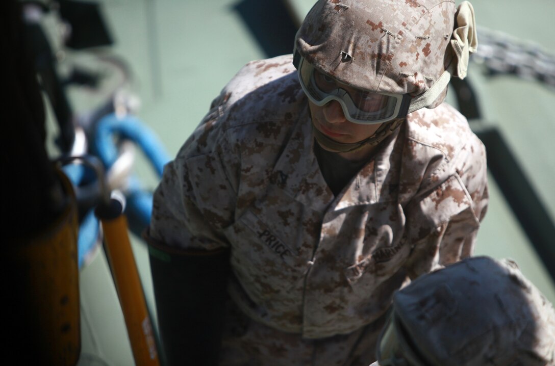 Lance Cpl. David S. Price, a landing support specialist with Combat Logistics Regiment 27, 2nd Marine Logistics Group, waits for a hook to be grounded during a training exercise aboard Camp Lejeune, N.C., Aug. 9, 2012. During the exercise, elements of the 2nd Marine Aircraft Wing supported the 8th Engineer Support Battalion’s efforts by providing a CH-53E Super Stallion from Marine Heavy Helicopter Squadron 366, which lifted individual pieces of the bridge at Landing Zone Sandpiper and dropped them at Engineer’s Point. (U.S. Marine Corps photo by Pvt. Franklin E. Mercado)