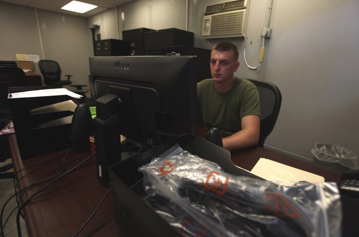 Cpl. Jonathon C. Head, a supply clerk with Combat Logistics Battalion 22, 2nd Marine Logistics Group, sits at his desk in the supply warehouse on Camp Lejeune, N.C., Aug. 9, 2012. Head not only holds the billet of a supply clerk but is also filling the role of the fiscal clerk while another Marine is absent. (U.S. Marine Corps photo by Sgt. Rachael K. A. Moore)