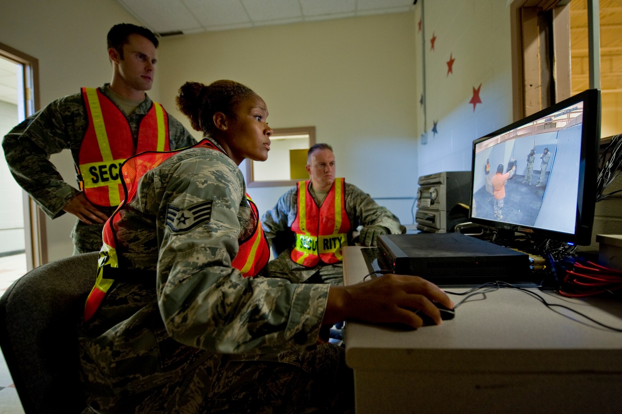 Staff Sgts. Ryan Michaels, Courtney Brock and Luke Frazier, 99th Security Forces Squadron training instructors, monitor an active shooter exercise in the 99th SFS shoot house Aug. 13, 2012, at Nellis Air Force Base, Nev. Cameras mounted on the walls enable instructors to see everything that happens during each scenario, even in total darkness. (U.S. Air Force photo by Staff Sgt. William P.Coleman)