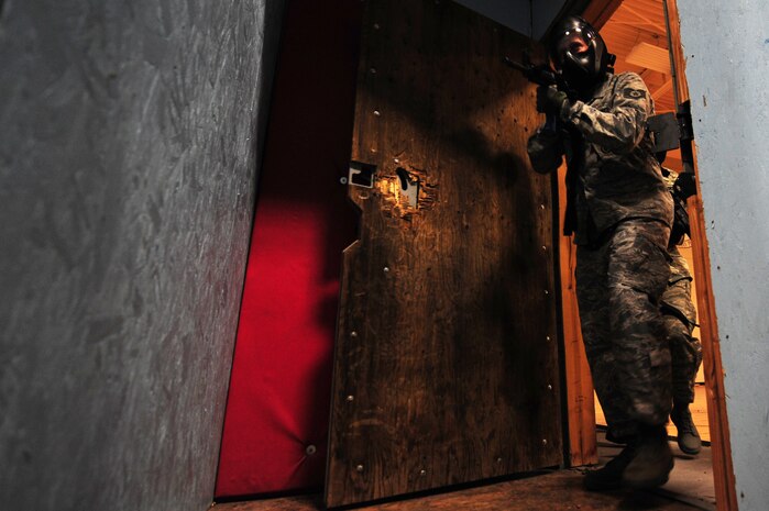 A member from the 99th Security Forces Squadron breaches a door in the 99th SFS shoot house during a controlled exercise Aug. 13, 2012, at Nellis Air Force Base, Nev. The 99th SFS, Las Vegas law enforcement and sister services use the shoot house for simulations of close quarters engagements. (U.S. Air Force photo by Staff Sgt. William P.Coleman)  
