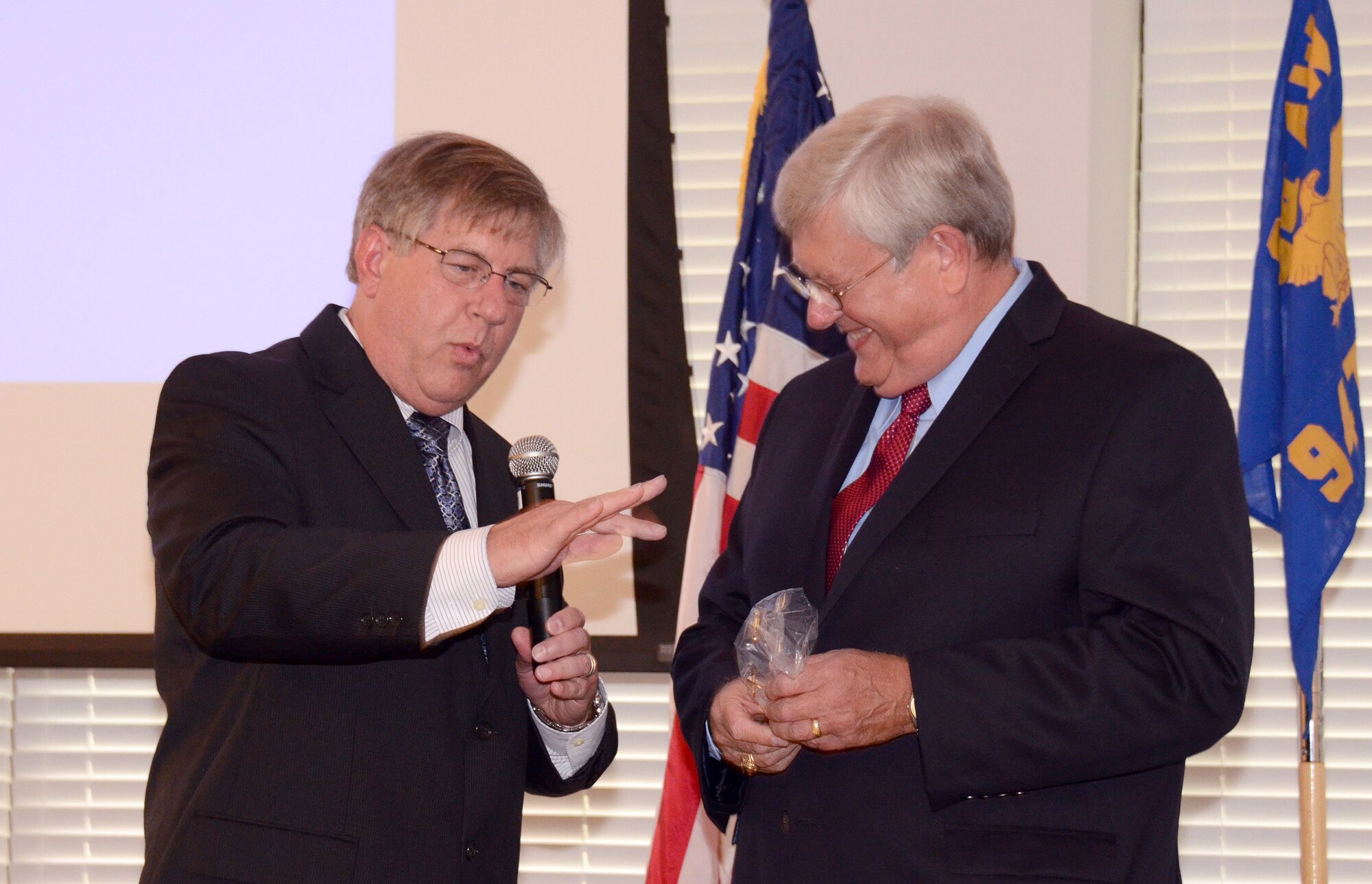 Mike Cantrell, chief of plans and programs for the 94th Communications Squadron, presents Clint Whitehead with a spinning coin display “so he won’t have to roll a coin through his fingers any more”, at Dobbins Air Reserve Base, Aug. 9. Clint Whitehead is retiring from the 94th Communications Squadron as the communications manager after 43 years of combined military and federal service.  (U.S. Air Force photo/Brad Fallin)