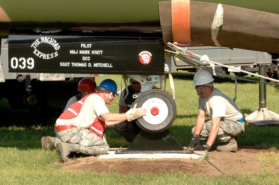 Airmen from 20th Equipment Maintenance Squadron and 20th Civil Engineering work together with Airmen from McEntire Joint National Guard Base to mount the front wheel an F-111 Aardvark at Shaw Air Force Base, S.C., Aug. 13, 2012. The aircraft is slated to be dedicated at the Air Park on Sept. 12 at 1 p.m. (U.S. Air Force photo by Airman 1st Class Krystal M. Jeffers/Released)