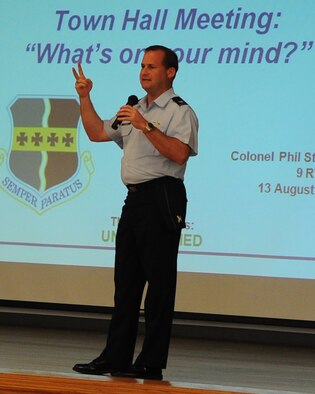 The commander of the 9th Reconnaissance Wing, Col. Phil Stewart, hosts a town hall meeting for Airmen and their families at the Community Activity Center, Beale Air Force Base, Calif., August 14, 2012. During the meeting department heads briefed the new Food Transition Initiative, back to school, the Eagle Eyes program, housing privatization and welcomed questions from guests. (U.S. Air Force photo by Senior Airman Shawn Nickel/Released)