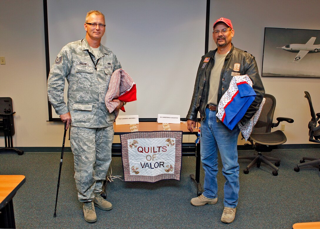 Tech. Sgt. Lawrence Bredwell (left) and retired Army Sgt.1st Class Christopher Chebahtah were both presented with Quilts of Valor during a presentation ceremony Aug. 8 at Building 2800. The Quilts of Valor Foundation is a foundation that presents quilts to servicemembers and veterans as a way of paying tribute and honoring those servicemembers. Bredwell is currently a fighter aircraft crew chief with the 31st Test and Evaluation Squadron and Mr. Chebahtah is an electrical technician with the 412th Maintenance Group Bomber Instrumentation shop. (U.S. Air Force photo by Jet Fabara)