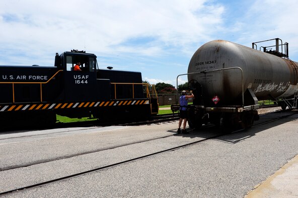 Adam McDowell (left), 20th Logistics Readiness Squadron D-Flight engineer/conductor, watches as Michelle Hill, 20th LRS D-Flight conductor/engineer turns the hand brake on a tank car, securing it in place at Shaw Air Force Base, S.C., August 9, 2012. The handbrake must be engaged when a car is not attached to the locomotive to prevent it from rolling away on slated terrain. (U.S. Air Force photo by Airman 1st Class Daniel Blackwell/Released)