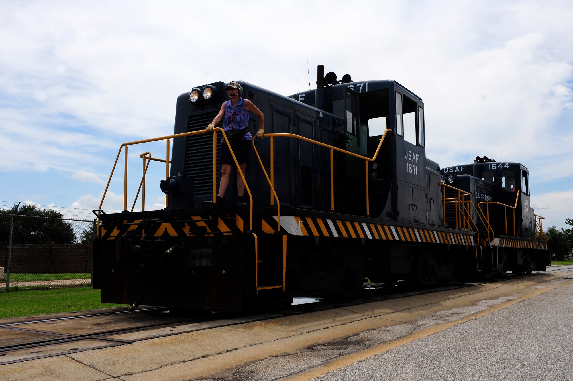 Michelle Hill, 20th Logistics Readiness Squadron D-Flight conductor/engineer, stands at the front of the locomotive as a second set of eyes for Adam McDowell, 20th LRS D-Flight engineer/conductor as he prepares to lead the remaining tank cars into the fueling station at Shaw Air Force Base, S.C., Aug. 09, 2012. The locomotives McDowell operates weigh 80 tons each; therefore precautionary measures are taken to reduce the chance of injury and or damage to property or personnel. (U.S. Air Force photo by Airman 1st Class Daniel Blackwell/Released)