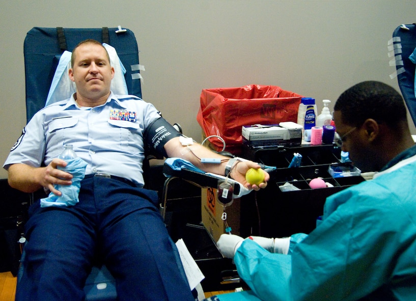Master Sgt. Joseph Ross has blood drawn by hospital man Andres Rodriguez-Brown during a military-to-military blood drive Aug. 6, 2012, at Dover Air Force Base, Del. Team Dover donated more than 80 units of blood that were sent to service members downrange in approximately 24 hours. One unit of blood has the potential to save three lives. (U.S. Air Force photo by Adrian Rowan)