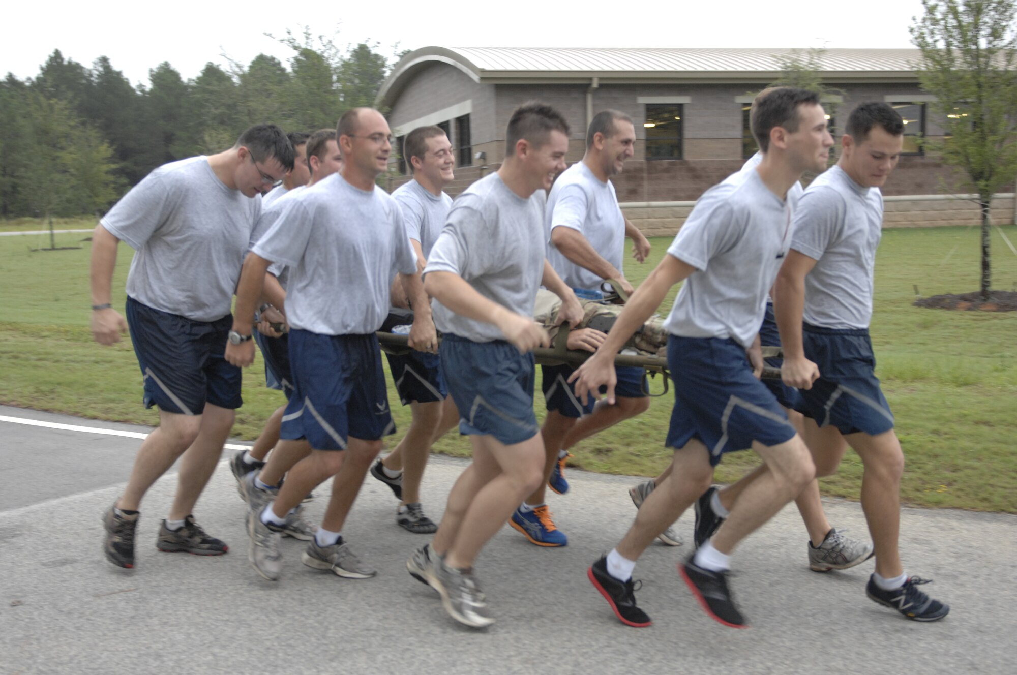 Airmen from 20th Civil Engineering Squadron, Explosive Ordinance Disposal  run together carrying a dummy during the 5K Poker Run at Shaw Air Force Base, S.C., Aug. 10, 2012. They trained carrying the dummy to promote team work and practiced the concept “never leave an Airman behind.” To support that belief, they carried the dummy through the entire 3 ½ mile race. (U.S. Air Force photo by Airman 1st Class Krystal M. Jeffers/Released)