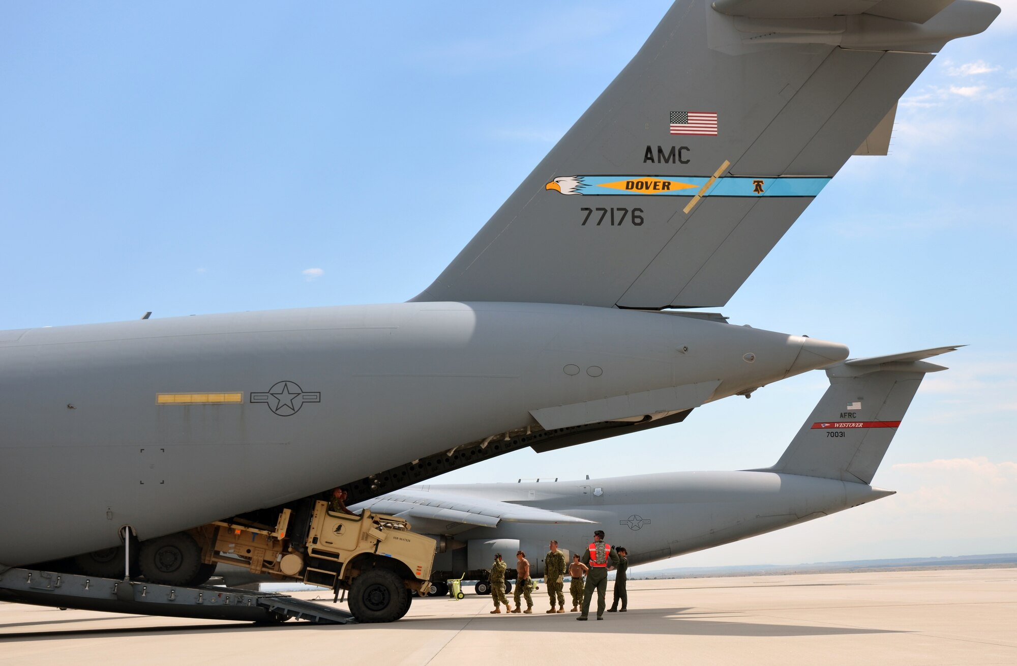 Master Sgt. Michelle Hite of the 326th Airlift Squadron, Dover Air Force Base, Del., marshals a Navy Seabees' vehicle off of a C-17 Globemaster aircraft Aug. 10, 2012, in Colorado Springs, Colo., as Senior Master Sgt. Desmond Mullally, 439th Airlift Control Flight, Westover Air Reserve Base, Mass., and members of Navy Mobility Construction Battalion 17 watch. The work was done as part of exercise Patriot Express 2012 in Colorado Springs and Pueblo, Colo. (U.S. Air Force photo by Senior Airman Kelly Galloway)