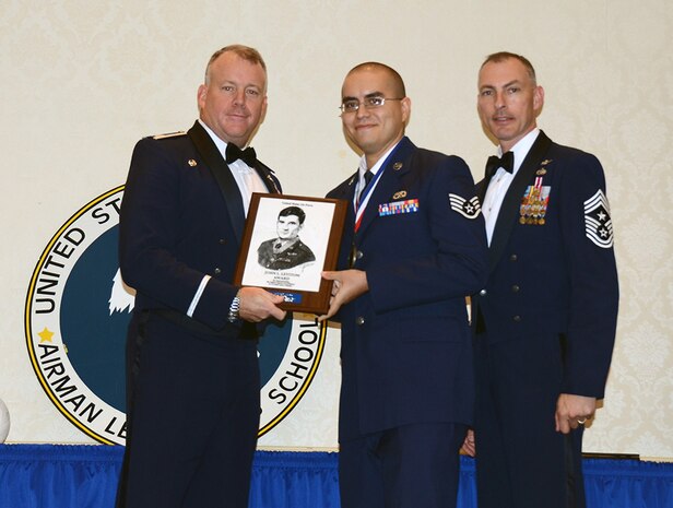 Col. Erik Hansen, 437th Airlift Wing commander and Chief Master Sgt. Larry Williams, 437th AW command chief, presents Staff Sgt. Kevin Thomas, 437th Aircraft Maintenance Squadron integrated avionics system craftsman, the John L. Levitow Award during the Airman Leadership School Class graduation Aug. 9 2012, at Joint Base Charleston - Air Base, S.C. The Levitow Award is given for a student's exemplary demonstration of excellence, both as a leader and scholar. (U.S. Air Force illustration / Airman 1st Class Tom Brading)