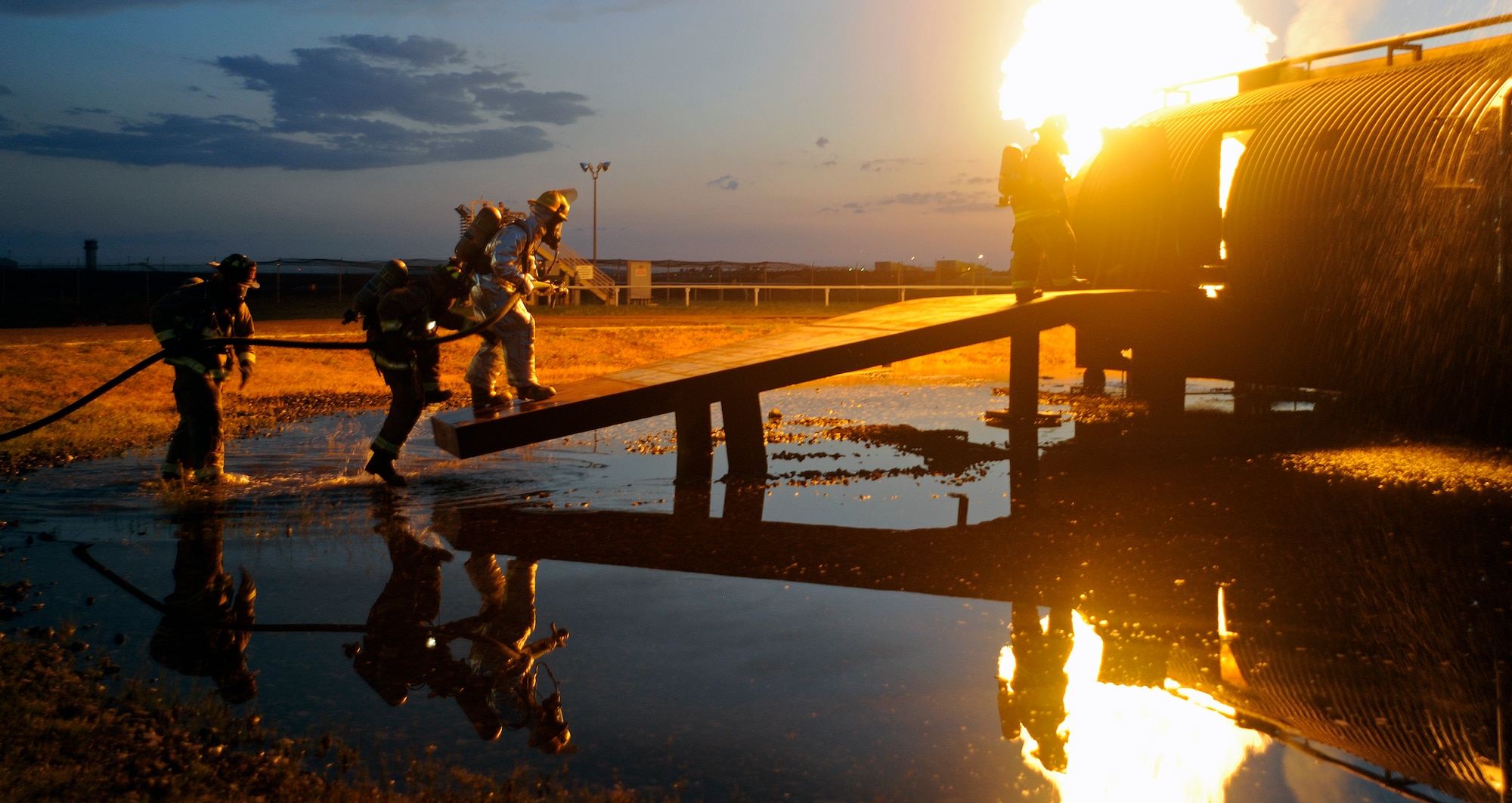 Fairchild Firemen approach the simulated aircraft fire at Fairchild Air Force Base, Wash., July 10, 2012. The firefighters are required to enter the aircraft and contain the fire. (U.S. Air Force photo by Airman 1st Class Ryan Zeski)