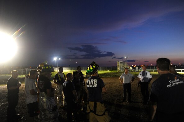 Members of the Fairchild Fire Department are debriefed after simulated live fire training at Fairchild Air Force Base, Wash., July 10, 2012. Firefighters are required to have at least four live fires each year in order to stay current with regulations. (U.S. Air Force photo/Airman 1st Class Ryan Zeski) 

