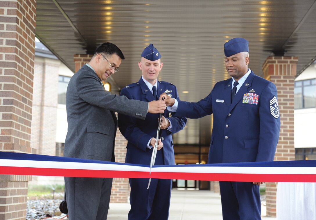 Mr. Noel Huliganga, Presidential Inn manager; Col. William Knight, 11th Wing/Joint Base Andrews commander; and Chief Master Sgt. William Sanders, 11th Wing/Joint Base Andrews command chief, cut a ribbon to signify the opening of the Andrews Temporary Living Facility at Joint Base Andrews, Md., Aug. 14, 2012.  The TLF building is located at the corner of Colorado avenue and F street, and is able to house 50 families. (U.S. Air Force photo/Staff Sgt. Torey Griffith)
