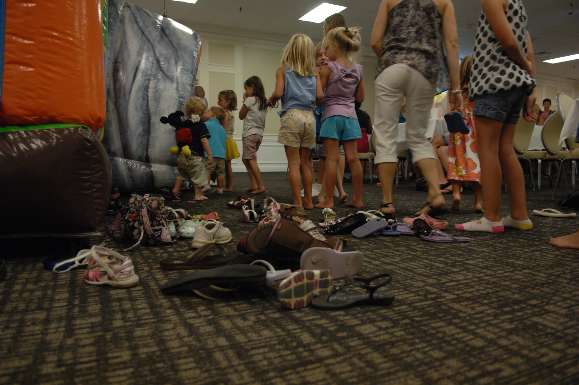Children abandon their shoes as they line up to enter the bouncy castle, set up for the Deployed Spouses Dinner; inside the main ball room of Carolina Skies Club, Shaw Air Force Base, S.C.,  Aug. 13. More than 200 attended this event sponsored by chapel services. (U.S. Air Force Photo by Staff Sgt. Ave I. Young/Released)