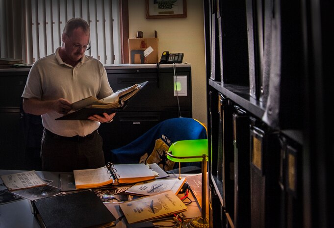 Stan Gohl, 437th Airlift Wing historian, looks through historical documents at Joint Base Charleston - Air Base, S.C. Gohl has been assigned to JB Charleston - Air Base for five years and spent 21-years as an active-duty Airman, 11 of those as an active-duty historian. (U.S. Air Force photo / Airman 1st Class Tom Brading)