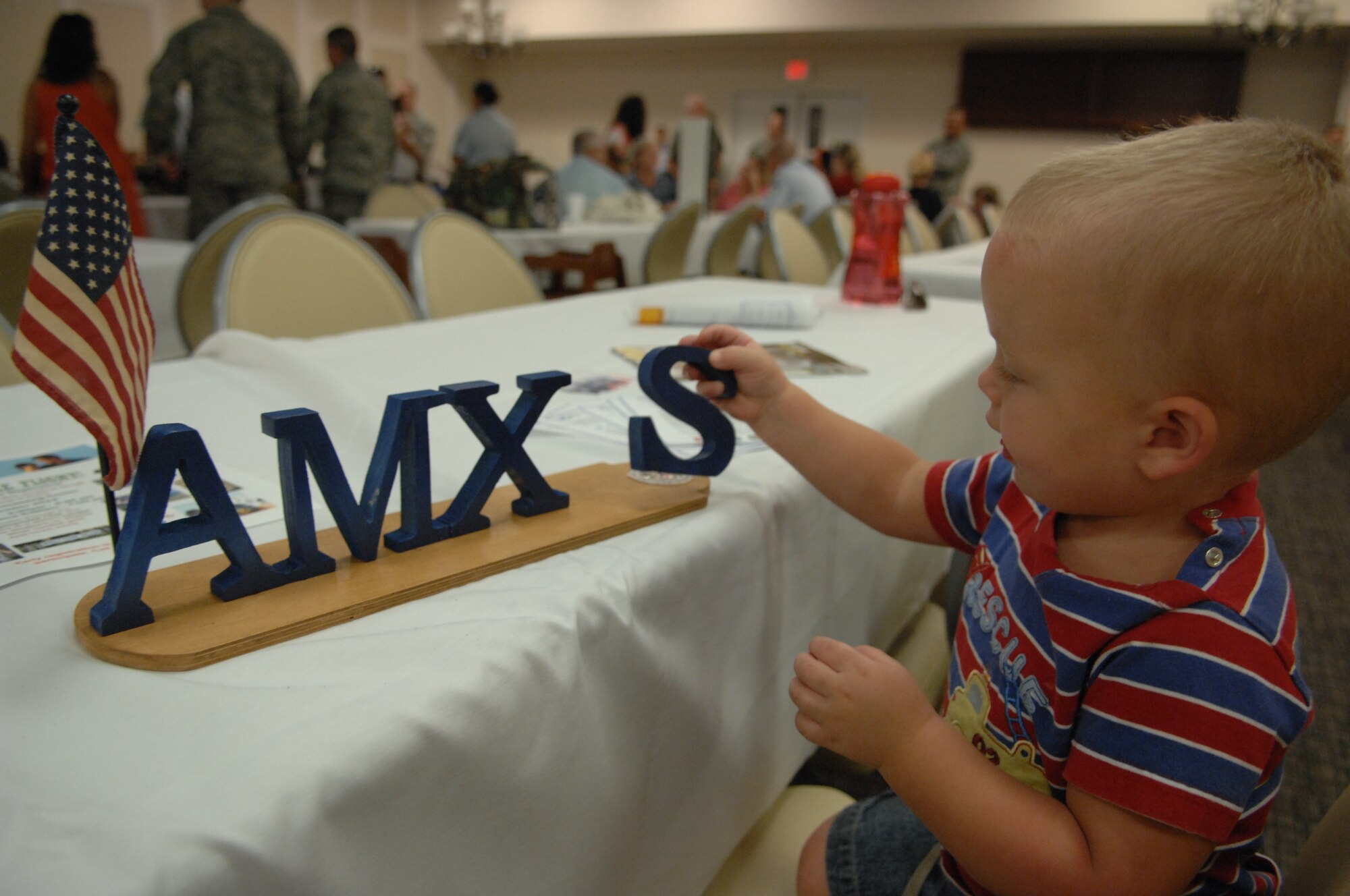 Justin Diener, two-year-old son to Senior Airman Joshua Diener, 20th Air Maintenance Squadron, and Jeni Diener, 20th Air Maintenance Squadron key spouse; plays with the letters of a table beacon set out for the Deployed Spouses Dinner, held at Carolina Skies, Shaw Air Force Base, S.C. Aug. 13. More than 200 people attended this event sponsored by chapel services. (U.S. Air Force Photo by Staff Sgt. Ave I. Young/Released)